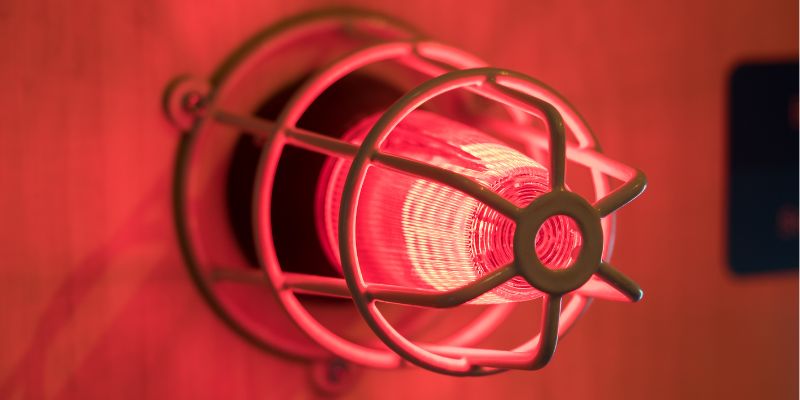 Close up of an alarm light with red wall